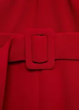 Mono largo de poliéster color rojo con cuello halter cruzado, sin mangas y cinturón con hebilla.