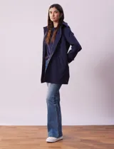 Gabardina impermeable color beige, marca Weatherproof, con abertura central con botones, bolsillos delanteros y capucha desmontable.