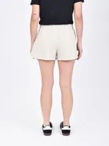 Short negro de tela suave con cintura elástica ajustable con cordón, bolsillos laterales y corte redondeado en los laterales.