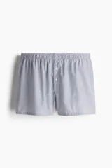 Pack de cinco calzoncillos boxer de algodón con cintura elástica, piernas largas y cierre de botón. Incluye calzoncillos lisos en azul marino, a rayas verticales en azul y blanco, y a cuadros en azul y blanco.