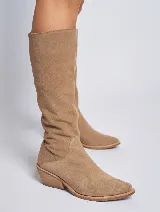 Bota de caña alta color beige, confeccionada en gamuza, con taco de madera y punta fina.