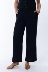 Pantalón negro de lino, de corte palazzo y tiro alto.