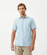 Camisa de algodón celeste con manga corta, cuello camisero, abotonadura frontal y bolsillo en el pecho.