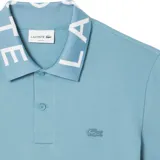 Polo celeste de piqué de algodón con cuello jacquard con la inscripción Lacoste en blanco.