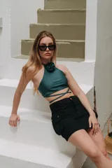 Minifalda de jean azul con corte en A y bolsillos tipo cargo con solapa y botón. Tiene un chaleco haciendo juego con cierre de botones.