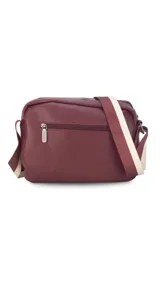 Bandolera bordeaux de cuero sintético con apertura central con cierre metálico. Tiene un bolsillo principal con cierre y un bolsillo frontal con tapa y broches magnéticos. Incluye bolsillos internos y posterior, y correa de galón combinada larga y regulable.