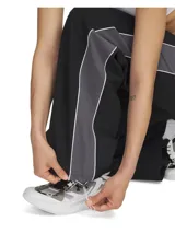 Pantalón deportivo Under Armour Rival Woven para mujer, color negro con detalles en gris y logo blanco.