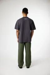 Remera de algodón color crema, corte oversize, con cuello redondo y un pequeño logo bordado en forma de 'x' en color azul marino en el pecho.