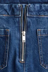 Pantalón de jean de tiro extra alto, color azul oscuro con efecto desgastado sutil. Corte de pierna amplia y recta, con puños anchos doblados. Presenta bolsillos parche cuadrados en la parte trasera y cierre expuesto en la espalda.