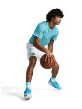 Short deportivo Under Armour con estampado abstracto en tonos naranja, amarillo y negro. Cintura elástica con logo Curry.