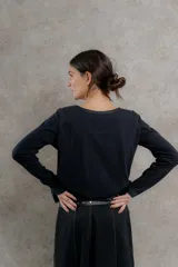 Remera negra de manga larga con costuras decorativas en color ocre en hombros y escote.