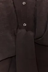 Camisa marrón con cuello solapa y mangas cortas. Cierre frontal con nudo y botones.
