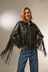 Chaqueta de cuero sintético negra con flecos en la espalda y mangas, cuello camisero, cierre frontal con cremallera y bolsillos laterales.