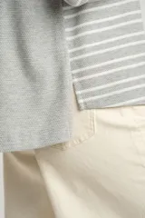 Sweater oversize gris con rayas horizontales blancas, de tejido suave y mangas largas.