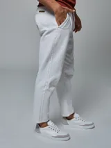 Pantalón color beige con cintura elastizada y cordón ajustable. Corte recto y bolsillos laterales.