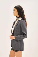 Saco de corte sastre con calce recto, confeccionado en lino con acabado foil que le da un brillo sutil.