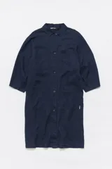 Chaqueta midi azul marino de lino, con cuello camisero, manga 3/4, cierre frontal con botones y bolsillos de parche en el delantero.