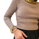 Pulsera dorada de bronce, compuesta por múltiples pulseras finas entrelazadas.
