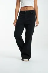 Pantalón de jean negro, de corte ajustado en cintura y caderas, con pierna ancha.