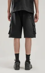Bermuda negra de algodón rústico, corte oversize, con cintura elástica y bolsillos cargo con cierre en los laterales.