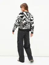 Sweater de punto con estampado abstracto de cebra en blanco y negro, de corte holgado y cuello redondo.
