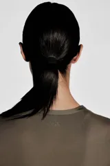Top deportivo corto color marrón, de corte ajustado, cuello redondo y mangas cortas. Confeccionado en tejido funcional DryMove™ que ayuda a absorber el sudor.