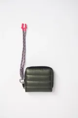 Billetera verde con diseño capitoneado, cierre de cremallera y correa de muñeca trenzada en tonos rosa y azul.
