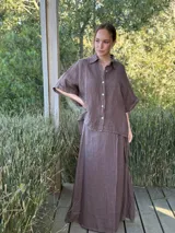 Camisa marrón de lino con botones blancos, corte holgado y mangas cortas.