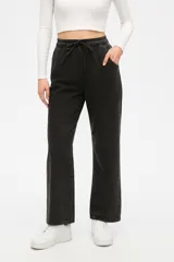 Pantalón de jean gris oscuro, corte ancho y tiro medio, con cintura elástica ajustable con cordón.