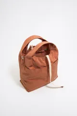Bolso de mano negro de nailon con estructura blanda, doble asa de mano y asa de tejido regulable. Cuenta con logo metálico BIMBA Y LOLA, acabados metálicos, bolsillo interior, cierre de cordón e interior con etiqueta de tejido.