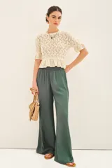 Pantalón palazzo negro de tiro alto con cintura elastizada y bolsillos diagonales.