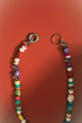 Collar corto de cuentas multicolores, con piedras naturales en forma de corazón y cuentas redondas de perla. Incluye cierres de mosquetón metálicos.