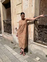 Vestido midi sin mangas color beige con estampado de líneas onduladas color ladrillo.