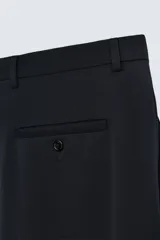 Pantalón de vestir negro slim fit confeccionado en tejido de lana de origen italiano. Cuenta con bolsillos frontales y traseros de vivo con botón. Cierre frontal con cremallera y botón. Colección especial Origins.