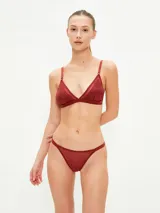 Conjunto de ropa interior color borgoña, compuesto por un bralette triangular con tirantes finos regulables y bombacha tipo tanga.