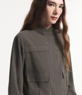 Campera bomber negra de viscosa con cierre delantero, bolsillos con solapa y pespuntes contrastantes en color blanco.