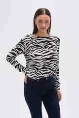 Sweater de tejido de punto, color crema, con estampado floral en tonos rosados y marrones. Presenta cuello redondo y mangas largas.