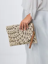 Cartera tipo sobre de rafia color beige con cierre de solapa y detalle de cuentas de madera en la correa de mano.