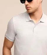 Remera polo de hombre, corte slim, color gris claro, confeccionada en tejido de media malla acanalada de algodón.