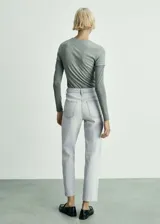 Pantalón de jean celeste claro, de corte recto, tiro alto y largo al tobillo.