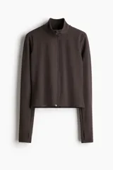 Campera deportiva corta color marrón, de corte ajustado, con cuello alto, cierre frontal con protección para el mentón y mangas largas con abertura para el pulgar. Confeccionada en tejido funcional SoftMove™ y DryMove™.