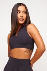 Top deportivo azul marino con cuello polo y cierre parcial con cremallera.