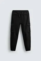 Pantalón cargo slim fit negro con cintura elástica ajustable con cordón, bolsillos frontales, traseros y laterales con solapa. Bajo con puño elástico.