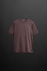 Camiseta marrón de corte relaxed fit, cuello redondo y manga corta. Confeccionada en tejido técnico ligero de tacto suave. Estampado de texto en el delantero y logo en el bajo.