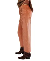 Pantalón de pana color naranja salmón, tiro alto, corte recto y largo cropped. Presenta cinco bolsillos y presillas para cinturón.
