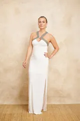 Vestido largo de fiesta color blanco, de jersey con cuello halter bordado con mostacillas plateadas.