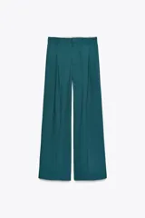 Pantalón marrón de tiro alto con trabillas, doble pliegue, bolsillos laterales y de vivo en la espalda, pernera ancha y cierre frontal con cremallera y gancho metálico.