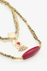 Collar de múltiples capas con cordón trenzado, cadena dorada y dije dorado.