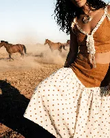 Top corto color terracota, con escote en V y tirantes anchos adornados con vivos de puntilla blanca. Presenta un lazo central en el escote.