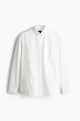 Camisa blanca de algodón Oxford con cuello americano, tapeta clásica, bolsillo superior abierto y canesú en la espalda. Mangas largas con puños abotonados y bajo levemente redondeado. Corte estándar.